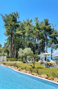 a resort with a swimming pool and a garden at Aroma Beach Hotel Bungalows in Limenas
