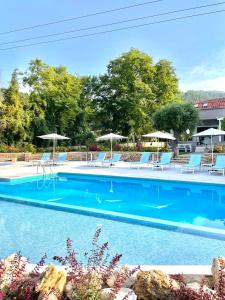 a swimming pool with lounge chairs and umbrellas at Aroma Beach Hotel Bungalows in Limenas