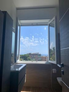 un bagno con ampia finestra e vista sulla città di TERRAZZA SUL MARE IN VIA DEVOTO a Chiavari