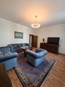 un soggiorno con divani, tavolo e TV di Old Town Cat Apartment a Klaipėda