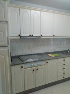 a white kitchen with white cabinets and a sink at APARTAMENTO RAFER in Ribadeo +18 photos