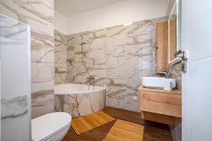 łazienka z wanną, umywalką i toaletą w obiekcie Apartments Junior w mieście Zadar +33 zdjęcia