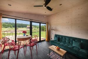 LipowoGóra Jabłek Mazury Mikolajki的客厅配有绿色沙发、桌子和椅子