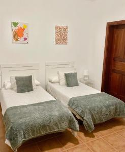 ラ・サンタにあるApartamento las quemadasのベッドルーム1室(ベッド2台、緑の枕付)