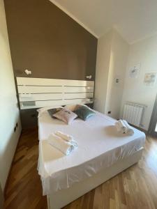 a bedroom with a white bed with towels on it at Flamingo Poetto in Quartu SantʼElena
