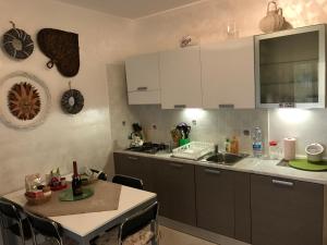 a kitchen with white cabinets and a table and a sink at Pizzo Beach Club, 11 G in Pizzo