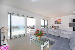 uma sala de estar com um sofá e uma mesa de vidro em Sunset Apartments em Makarska