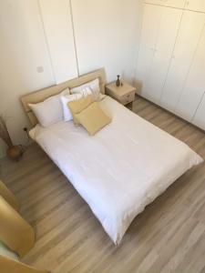 - un lit avec des draps et des oreillers blancs dans l'établissement Summer getaway: Stunning 1 bedroom apartment!, à Pólis Chrysochoús