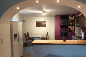 a kitchen and dining room with a table and an archway at Villard au cœur de la vallée verte entre lac et montagne in Villard-sur-Boëge