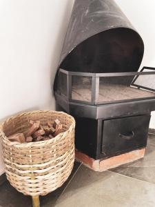 a charcoal grill with a basket next to it at Pousada Ilumina in São Francisco Xavier
