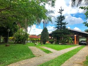 a driveway leading to a house with trees and grass at Chacara com WiFi, piscina e churrasq em Atibaia in Atibaia