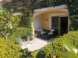 eine Terrasse mit einem Sofa, einem Tisch und Stühlen in der Unterkunft Pizzo Beach Club. One bedroom apt 13G in Pizzo