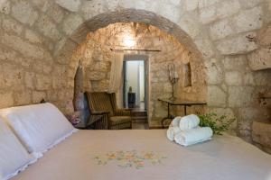 オストゥーニにあるIl Trullo di Martinoの石壁のベッドルーム1室(大型ベッド1台付)