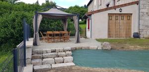 un patio con mesa y cenador en La maison du cœur, en Saint-Moreil