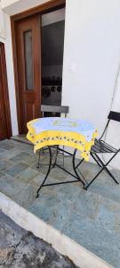 a yellow table and a chair on a patio at Mini Traditional House in Skiros