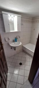 a white bathroom with a sink and a tub at Mini Traditional House in Skiros