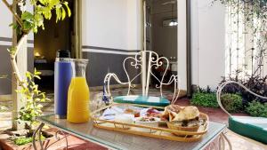 a table with a tray of food and a bottle of orange juice at Alem Colonial - Mendoza in Mendoza