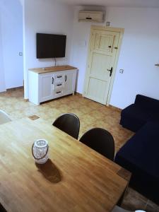 a room with a wooden table and a television at Tu Casa in Puerto de Mazarrón