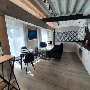 a living room with a couch and a table at Apartamenty Kąpielowa Biały in Ełk