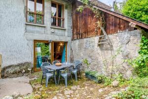 a table and chairs sitting outside of a building at Cosy flat in an old farmhouse with garden in Seynod - Welkeys in Annecy