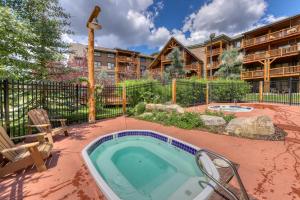 una bañera de hidromasaje en un patio junto a un edificio en Tenderfoot Lodge 2652, en Keystone