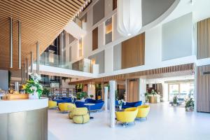 a view of the lobby of a hospital with yellow chairs at THE ONE CAORLE - Hotel & Apartments ****s in Caorle