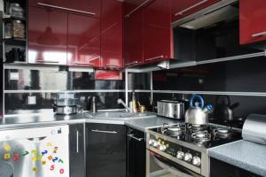 a kitchen with red cabinets and a stove top oven at Apartament rodzinny 2 pokojowy. Widok na Snieżke. in Karpacz
