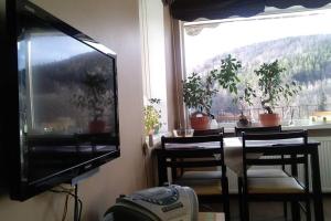 a living room with a television and a table and chairs at Apartament rodzinny 2 pokojowy. Widok na Snieżke. in Karpacz