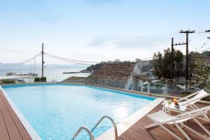 
a beach with a pool and a pool table at Melina Bay Boutique Hotel in Kassiopi
