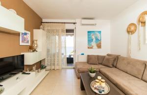 a living room with a couch and a tv at Thalassa Luxury Apartment in Paleo Tsifliki