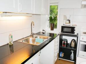 cocina con fregadero y microondas en 2 person holiday home in M NSTER S, en Mönsterås