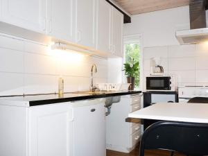 cocina blanca con fregadero y microondas en 2 person holiday home in M NSTER S, en Mönsterås