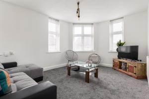 a living room with a couch and a tv at Lima Apartments Ltd-4 Beds-Large property -Long Stay Deal-Business-Parking in Bournemouth