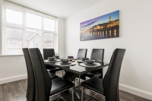 uma sala de jantar com uma mesa preta e cadeiras em Lima Apartments Ltd-4 Beds-Large property -Long Stay Deal-Business-Parking em Bournemouth