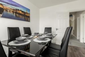 ein Esszimmer mit einem schwarzen Tisch und schwarzen Stühlen in der Unterkunft Lima Apartments Ltd-4 Beds-Large property -Long Stay Deal-Business-Parking in Bournemouth