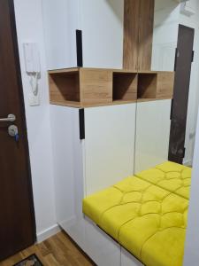 a room with a yellow bed in a room at Metropolitan in Zenica