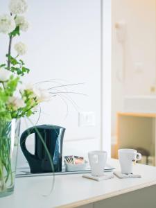 a table with a vase and two cups on it at Affittacamere Altamarea in La Spezia