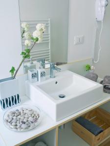 ein Badezimmer mit einem weißen Waschbecken und einem Spiegel in der Unterkunft Affittacamere Altamarea in La Spezia