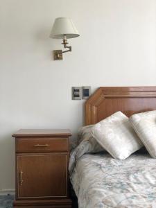 a bedroom with a bed with a nightstand and a lamp at B&B 518 in La Paz