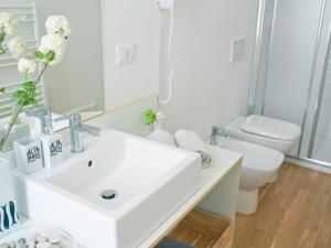 a white bathroom with a sink and a toilet at Affittacamere Altamarea in La Spezia