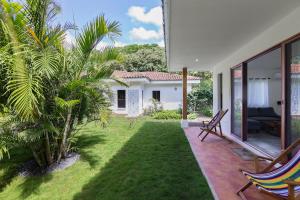 eine Terrasse mit Stühlen und einen Hof mit einem Haus in der Unterkunft Zen Casita + Studio in Rivas
