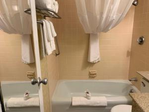 y baño con bañera, aseo y toallas. en Motel 6-Lincoln, NE - Airport, en Lincoln