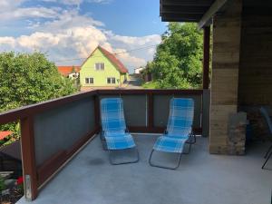 eine Veranda mit zwei blauen Stühlen und ein Haus in der Unterkunft Apartmán u Alfonse in Horní Lhota