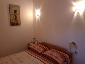 a bedroom with a bed and two lights on the wall at Apartman 2 -NENA- in Zadar