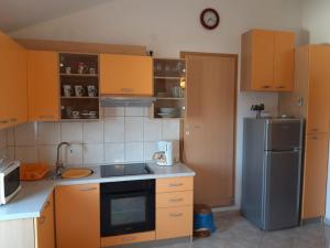 a kitchen with wooden cabinets and a stainless steel refrigerator at Apartman 2 -NENA- in Zadar