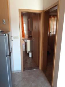 a hallway leading to a kitchen with a refrigerator at Apartman 2 -NENA- in Zadar