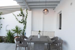 MarLeon في كالو ليفادي: طاولة طعام وكراسي في غرفة بجدران بيضاء