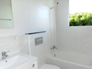 a white bathroom with a sink and a toilet at Apartamentos Casa Blanca in Miami Platja