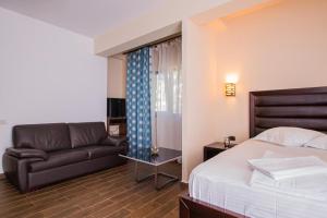 um quarto de hotel com uma cama e um sofá em Vila Matei - Eforie Nord em Eforie Nord