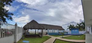 un pavillon avec un toit de paille et une clôture dans l'établissement Hotel Perlas del Golfo, à Chachalacas